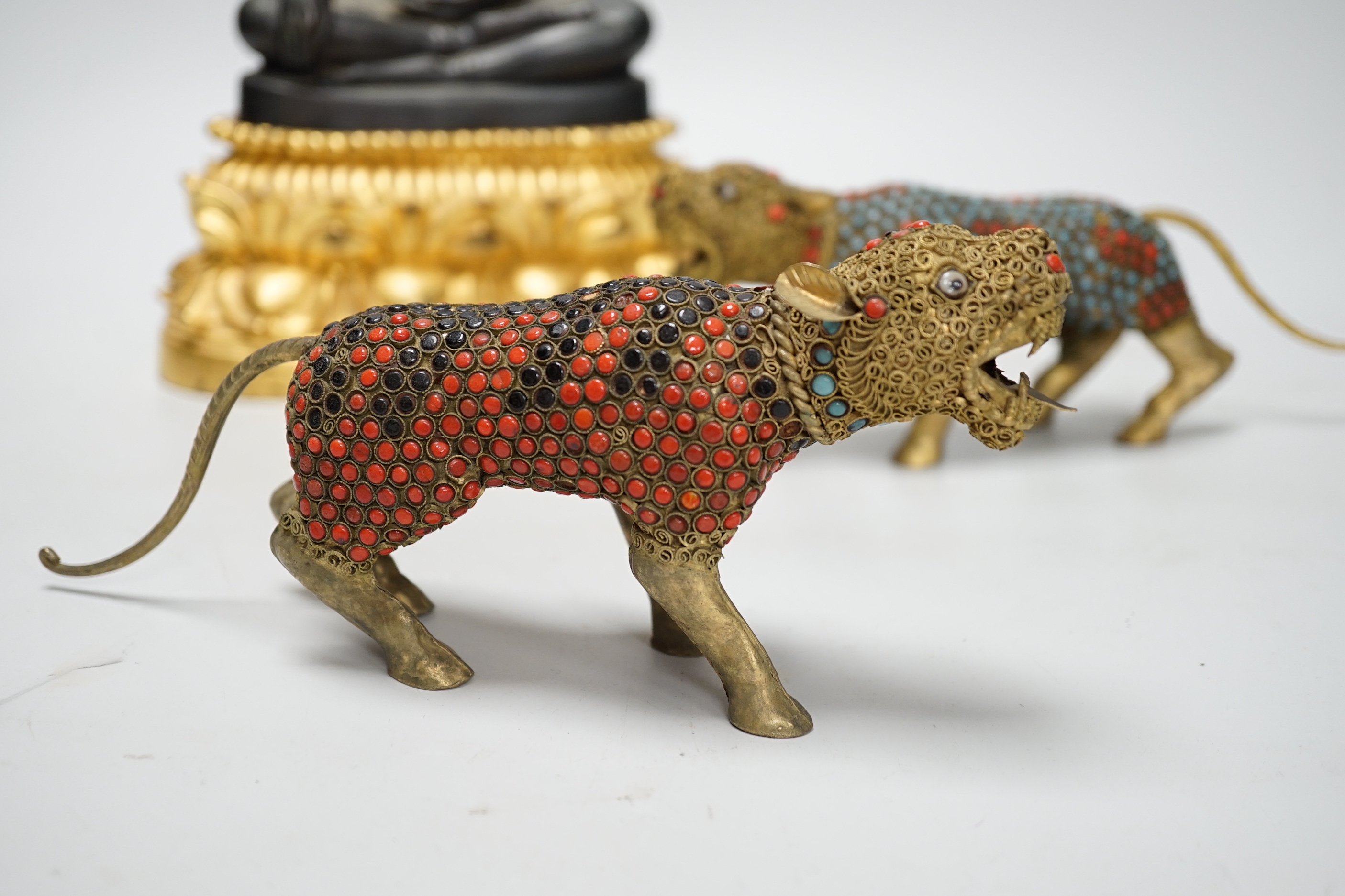 A Thai bronze Buddha raised on a gilt base and two filigree work brass and enamel tigers , the largest 26cm high